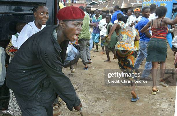 Government soldiers beats civilians as a peace rally is broken up near front line positions July 19, 2003 just outside Monrovia, Liberia. In an...