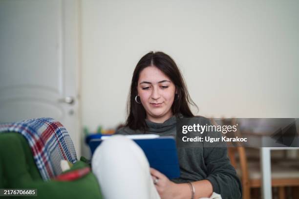 junge frau mit digitalem tablet und mobiltelefon auf der couch. - komfortzone stock-fotos und bilder