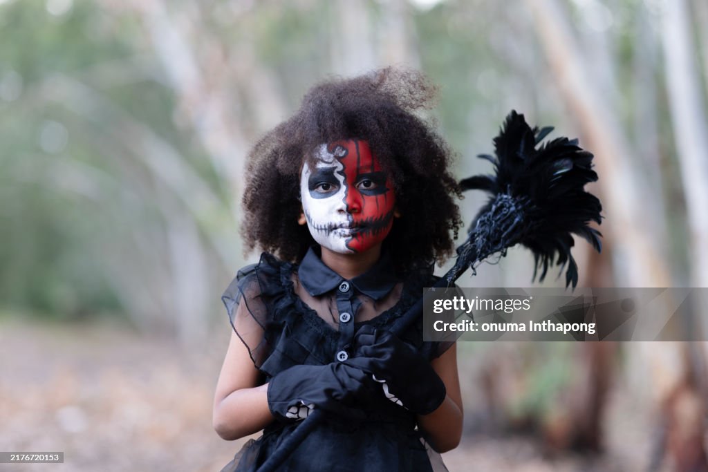 A cute goth girl with short curly hair wearing a black gothic dress, holding a Halloween decoration pumpkin. Ready for a Halloween gothic party