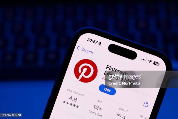 Laptop keyboard and Pinterest on App Store displayed on a phone screen are seen in this illustration photo taken in Poland on October 8, 2024.