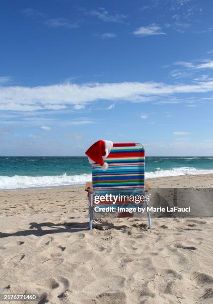 santa hat on an empty folding chair at the beach - ft lauderdale beach stock pictures, royalty-free photos & images