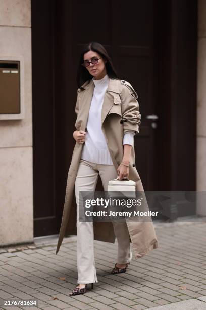 Leo Eberlin is seen wearing oval sunglasses with dark Havana frame and pink lenses and a gold logo at the temples from Miu Miu, a calf-length beige...