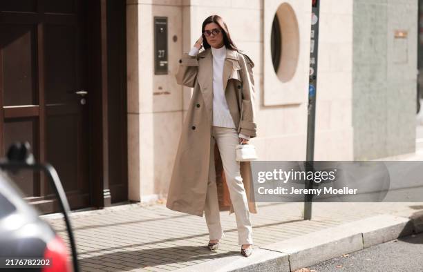 Leo Eberlin is seen wearing oval sunglasses with dark Havana frame and pink lenses and a gold logo at the temples from Miu Miu, a calf-length beige...