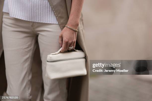 Leo Eberlin is seen wearing a calf-length beige trench coat from Zara, a white cashmere turtleneck pullover with ribbed trims from Allude, beige...
