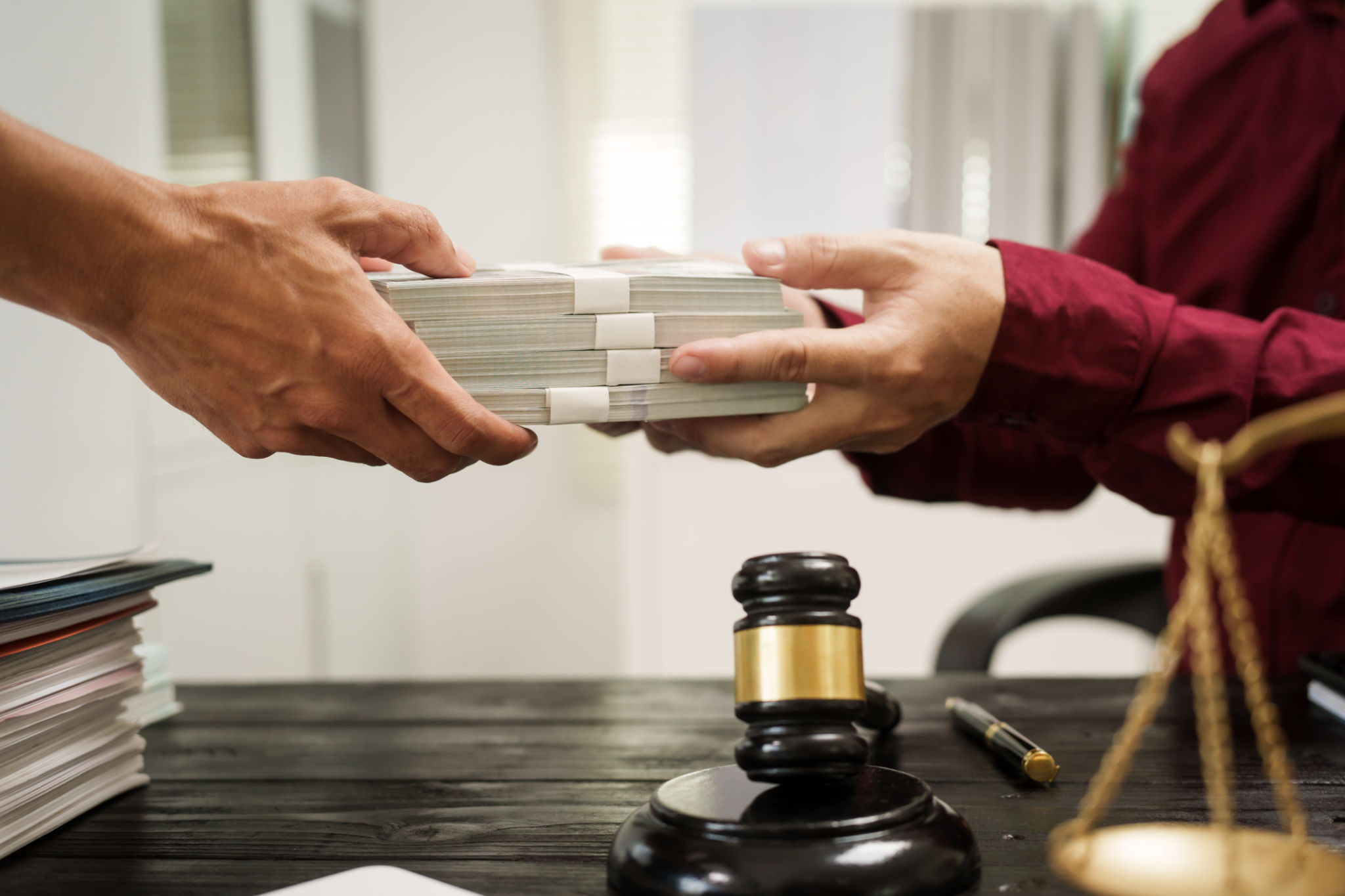 A male lawyer works at his desk, receiving cash from a client while considering the case. He focuses on law, justice, fairness, and the observance of legal rules and conventions in the system A male lawyer works at his desk, receiving cash from a client while considering the case. He focuses on law, justice, fairness, and the observance of legal rules and conventions in the system