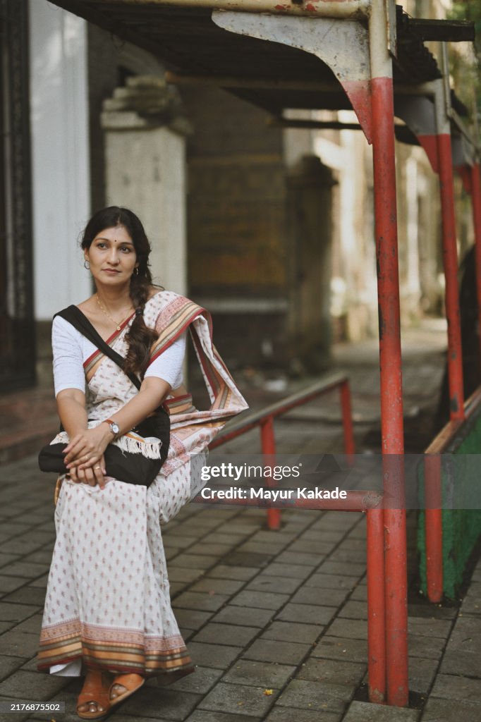 Indian Mid-Adult Woman waiting for a Bus at the Bus stop