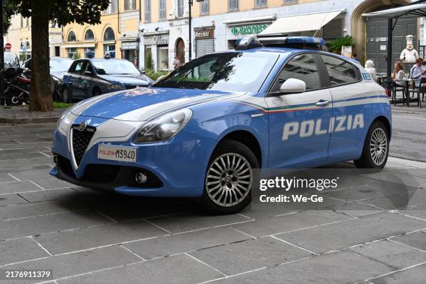 an alfa romeo giulietta as a police car of the “polizia” in the streets of bergamo, italy. - politieauto stockfoto's en -beelden