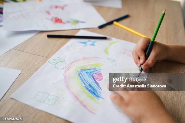 child's hands drawing with pencil at table - colorare foto e immagini stock