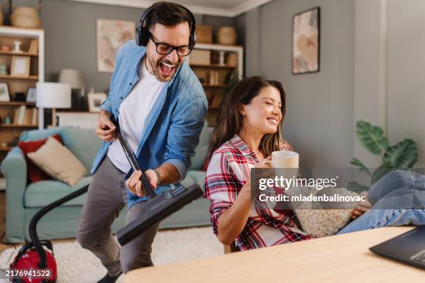 happy couple during home cleaning routine - popcorn floor stock pictures, royalty-free photos & images