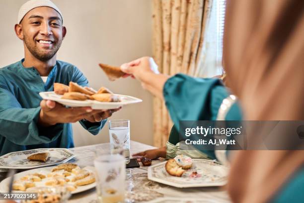 muslim family celebrating eid at home sharing food during ramadan - samosa stock pictures, royalty-free photos & images
