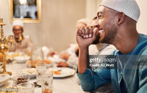 young muslim man smiling while having eid dinner with family during ramadan - iftar stock pictures, royalty-free photos & images