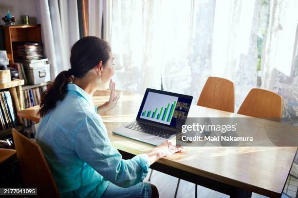 senior woman making credit card payments in living room of her home - flexible screen stock pictures, royalty-free photos & images