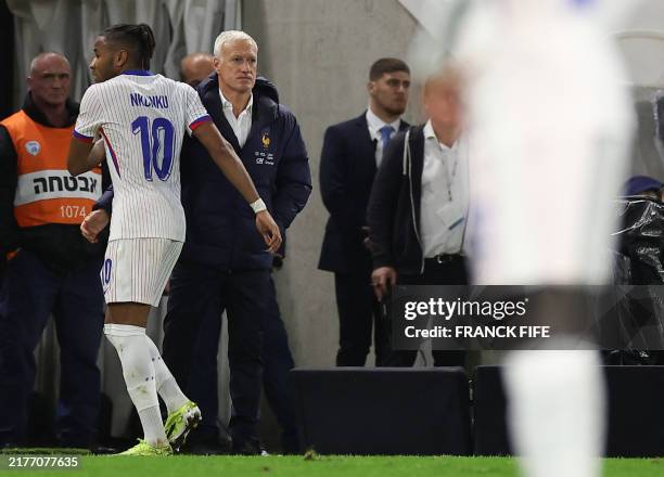 France's midfielder Christopher Nkunku is greeted by France's head coach Didier Deschamps as he leaves the pitch during the UEFA Nations League...