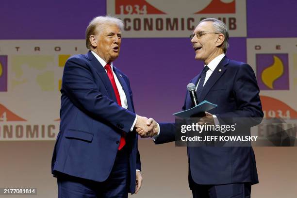 Former US President and Republican presidential candidate Donald Trump greets US Ambassador to the United Arab Emirates, John Rakolta during an...