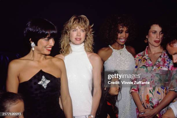 Nicaraguan actress Bianca Jagger, wearing a strapless black outfit, American model and actress Juliane Phillips , American singer and actress Whitney...