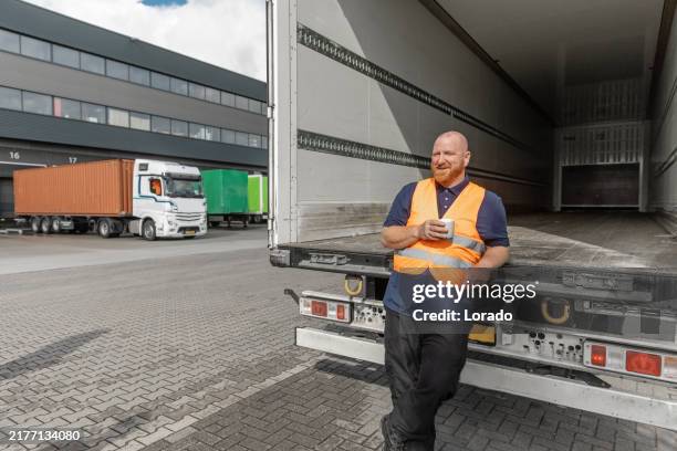 handsome middle aged man truck driver worker during his daily duties on site - vrachtwagenchauffeur stockfoto's en -beelden