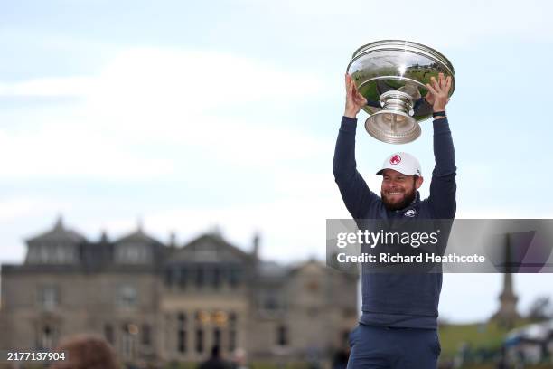 Tyrrell Hatton of England poses with the trophy on the Swilcan Bridge following victory on day four of the Alfred Dunhill Links Championship 2024 at...