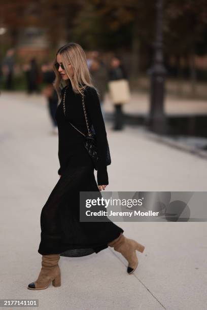 Pernille Teisbaek is seen wearing a long black dress with brown suede boots, a black Maxi leather Chanel handbag and black sunglasses during the...