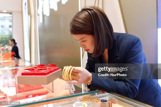 Staff member arranges gold ornaments at a gold shop in Renhuai, China, on October 11, 2024.