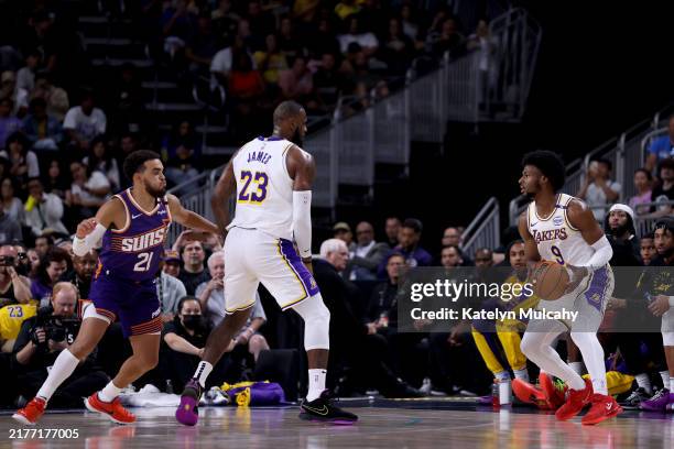 LeBron James of the Los Angeles Lakers sets a screen for Bronny James against Tyus Jones of the Phoenix Suns during the second quarter at Acrisure...