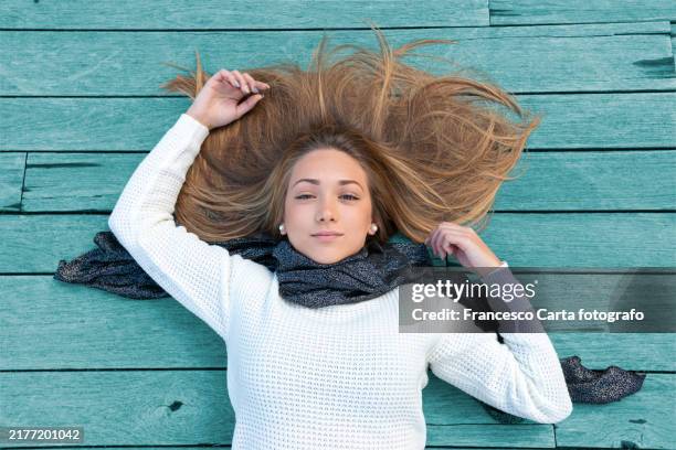above view of happy young woman lying down on wooden floor - tangled hair stock pictures, royalty-free photos & images