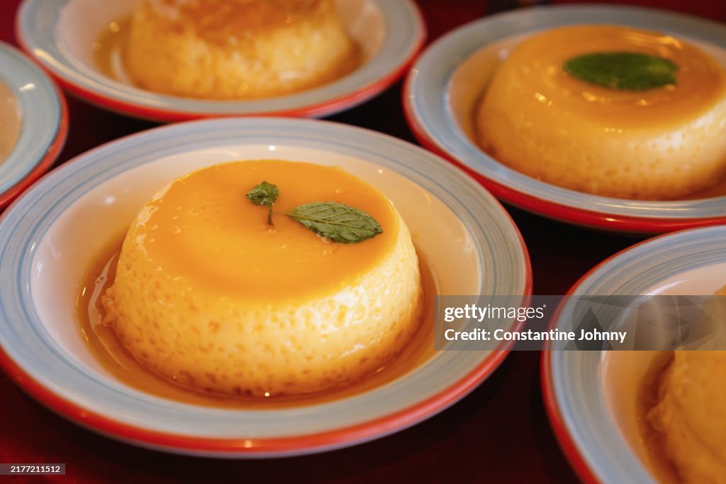 Caramel Flans with Mint Leaves on White Plates