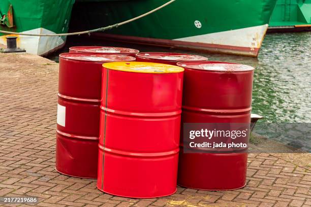 five red oil barrels stand on the quay - oil drum stock pictures, royalty-free photos & images