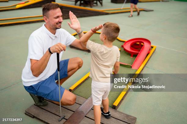 enjoying while playing mini golf - mini golf stock pictures, royalty-free photos & images