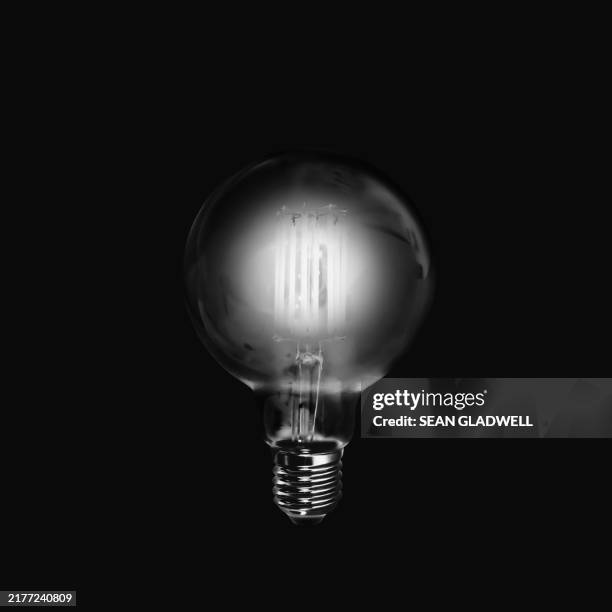 lightbulb on black - monochrome stock pictures, royalty-free photos & images