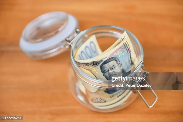 100 japanese yen banknotes in jar. - money-talks-englische-redewendung stock-fotos und bilder