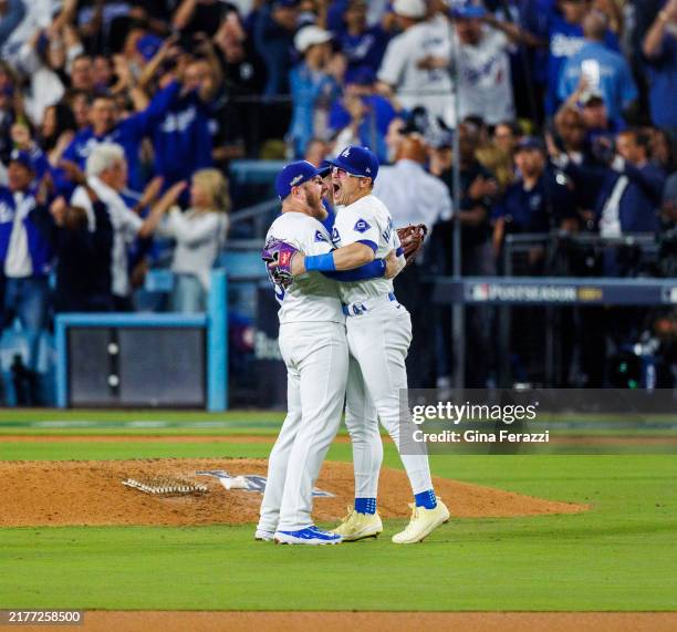Los Angeles Dodgers third baseman Max Muncy and Los Angeles Dodgers shortstop Enrique Hernandez , right, embrace after the Dodgers beat the Padres to...