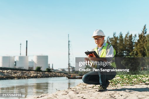 Male petroleum refinery engineer uses tablet to check work at a beachside job site. Male petroleum refinery engineer uses tablet to check work at a beachside job site.