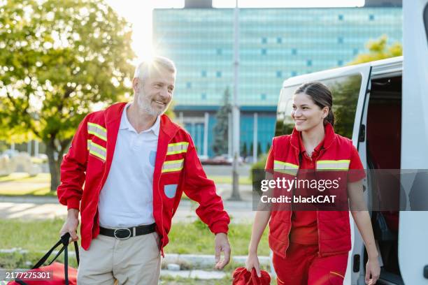 cheerful paramedics walking outdoors on a sunny day - openbare dienstverlening stockfoto's en -beelden