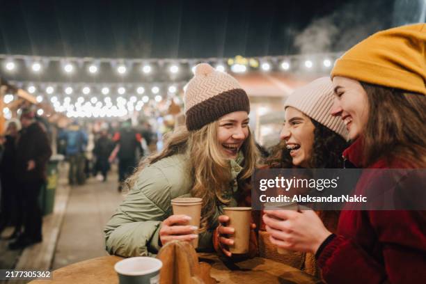 the young girls are having a nice time at christmas market - julmarknad bildbanksfoton och bilder