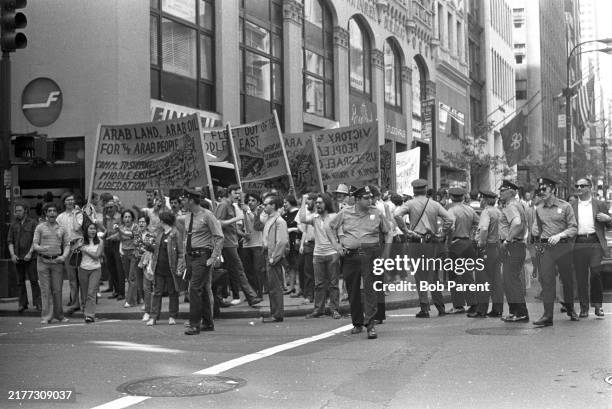 Demonstrators march past the Finnair office at 51st Street in New York City, New York, escorted by several policemen. Chanting with raised fists, the...