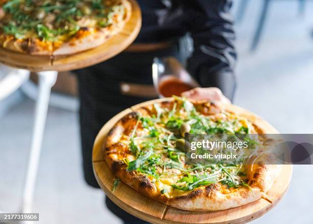 waiter serving pizza - pizzeria stock pictures, royalty-free photos & images