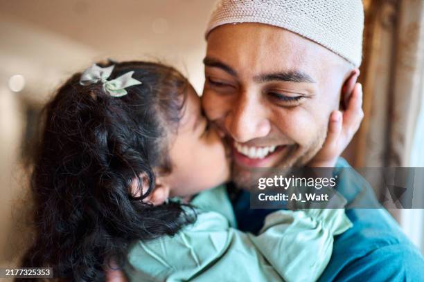 laughing muslim father being kissed on the cheek by his little girl - ramadan stock pictures, royalty-free photos & images