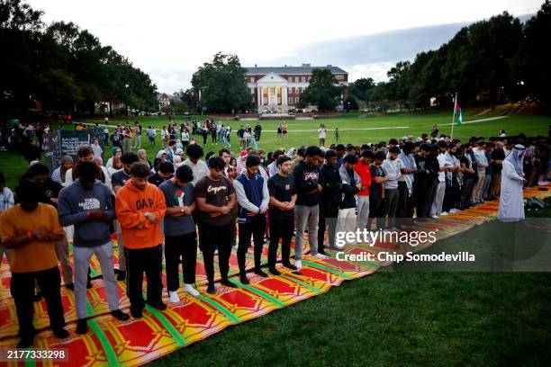 Attendees pray during a vigil organized by the Students for Justice in Palestine along McKeldin Mall in the heart of the University of Maryland...