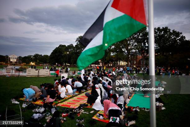 Attendees pray during a vigil organized by the Students for Justice in Palestine along McKeldin Mall in the heart of the University of Maryland...