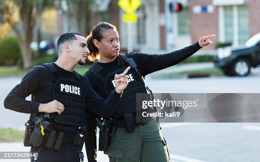Two police officers patrolling community on foot Two police officers patrolling community on foot