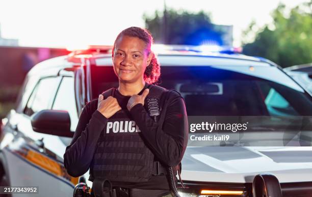 policía multirracial de pie con coche patrulla - cuerpo de policía fotografías e imágenes de stock