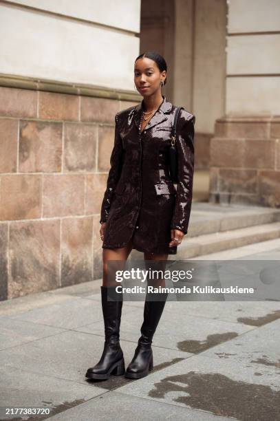 Amaka Hamelijnck wears brown sequins long sleeve jacket as a dress, black bag and long black boots outside the Rotate show during day four of the...