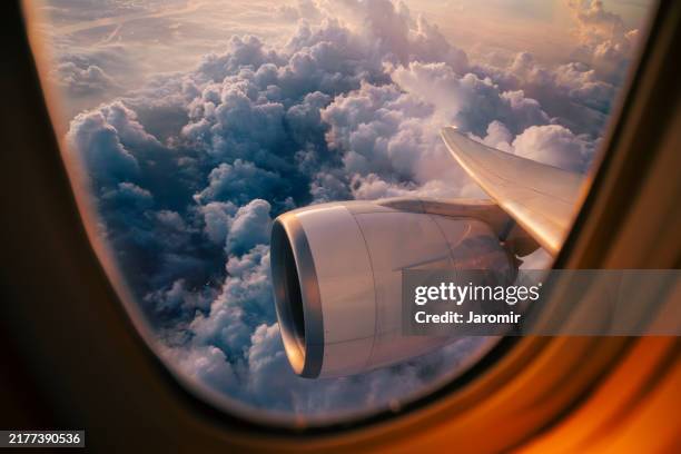 view through airplane window during flight at sunset - view out airplane window stock-fotos und bilder