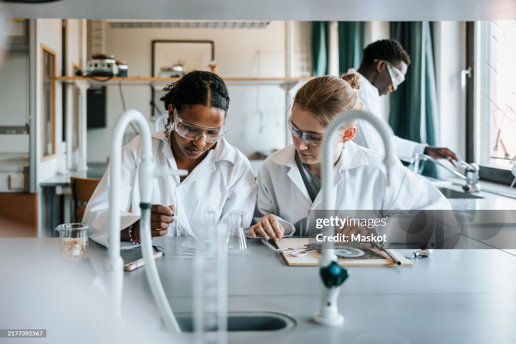 Multiracial female students doing experiment in science laboratory