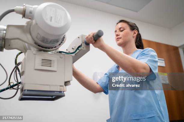 medizintechniker, der das röntgengerät in der klinik einrichtet - röntgenaufnahme stock-fotos und bilder