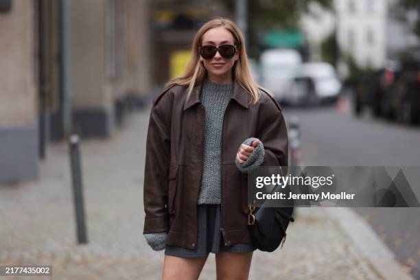 Sonia Lyson is seen wearing round aviator sunglasses with a tortoiseshell frame, brown lenses, and rounded wide temples featuring gold logo...