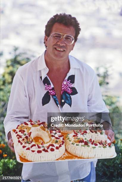 The Italian singer Peppino di Capri poses smiling with the cake to celebrate his 50th birthday. Capri , July 1989