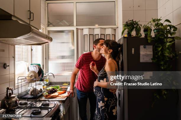 ehemann küsst schwangere frau zu hause - besonderes lebensereignis stock-fotos und bilder