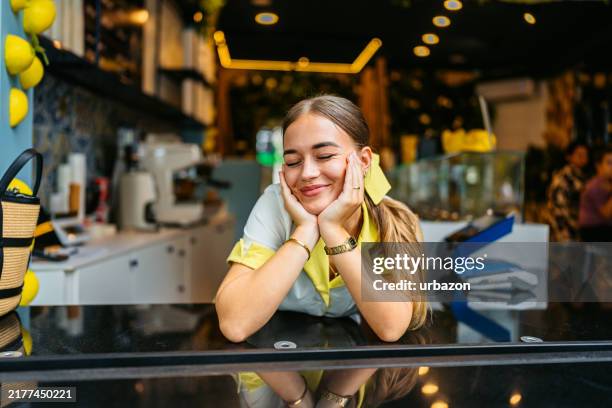 young woman working in an ice cream shop - gefrorener joghurt stock-fotos und bilder