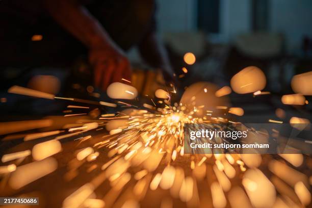 explosive sparks: the art of metal grinding - industria metálica fotografías e imágenes de stock